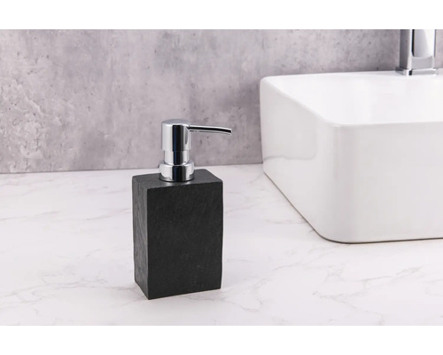 Seifenspender aus Stein mit Chrompumpe neben Waschbecken