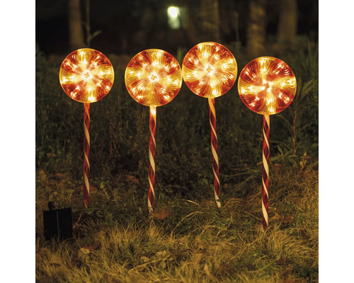 Vier leuchtende Solar-Lutscher als Gartenstecker im Gras