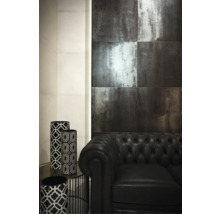 Scène avec carreaux muraux sombres, canapé en cuir noir et vases décoratifs à motifs géométriques