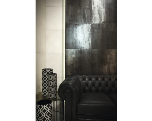 Intérieur avec carrelage mural aspect métal, canapé en cuir noir et vases décoratifs