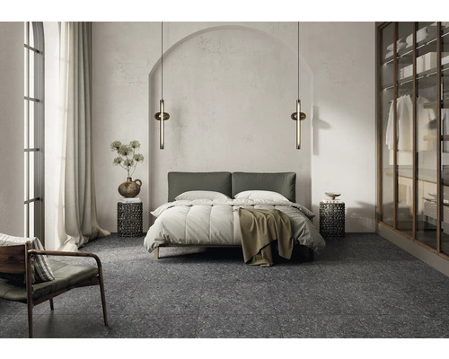 Chambre à coucher avec lit, tables de chevet, lampadaires et fauteuil sur un sol en terrazzo.