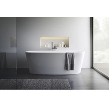 Modernes Badezimmer mit freistehender Badewanne, Armatur und Pflegeprodukten in einer Nische