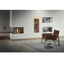 Wohnzimmer mit Kamin, Holzscheitregal und Sessel auf Teppich