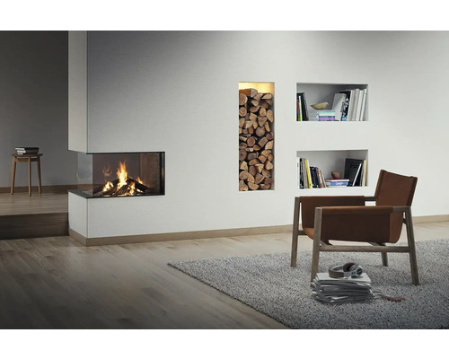 Salon avec cheminée, étagère à bois et fauteuil sur tapis