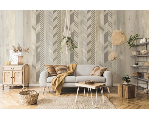 Wohnzimmer mit grauem Sofa, Holztisch, Holzkiste und Wandtapete mit Pfeilmuster.