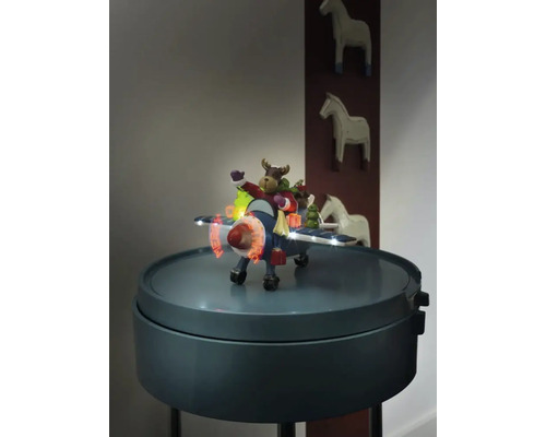 Dekoratives Flugzeug mit Elchfigur und Beleuchtung auf einem Beistelltisch