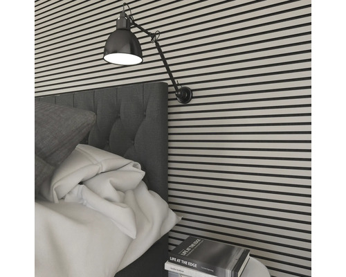 Gros plan d''une chambre avec des panneaux muraux, un lit, une lampe et une table de chevet