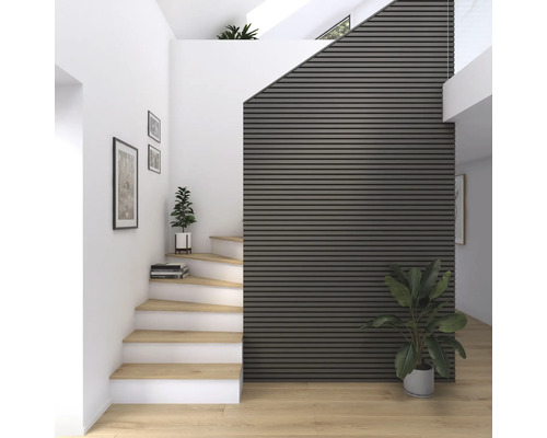 Hall d''entrée lumineux avec escalier, parquet et panneaux acoustiques au mur.