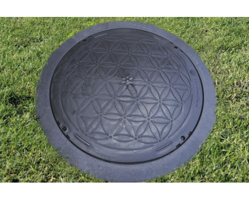 Couvercle de regard rond avec motif floral sur la pelouse