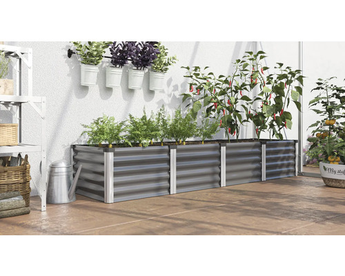 Jardinière surélevée en métal avec plantes, herbes aromatiques et légumes sur une terrasse.
