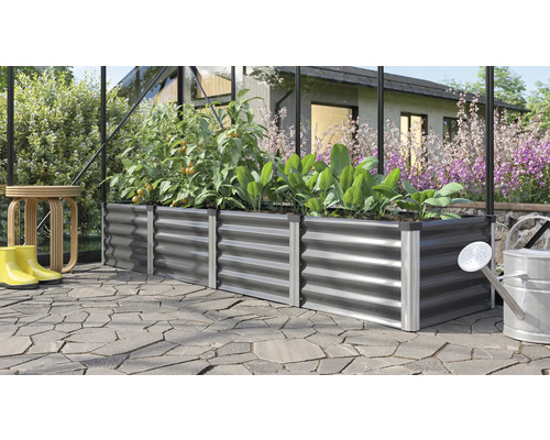 Jardinière surélevée en métal avec plantes, arrosoir et bottes en caoutchouc