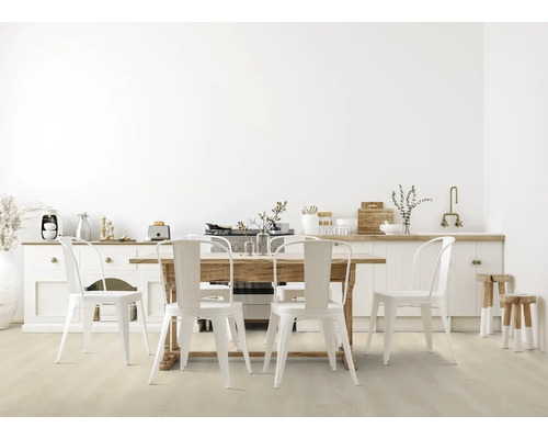 Salle à manger claire avec table en bois, chaises en métal blanc, buffet et tabourets.
