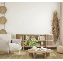 Wohnzimmer mit Sessel, Holztisch, Bücherregal und Dekorationen in hellem und freundlichem Design