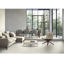 Helles Wohnzimmer mit Sofa, Stühlen, Tisch und großem Fenster mit Blick auf Bäume