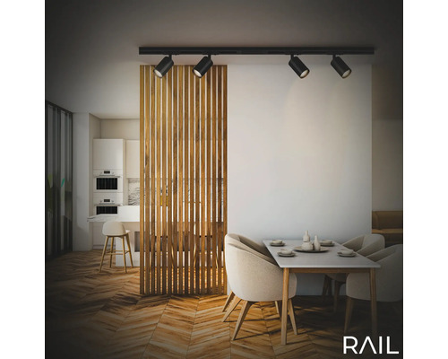 Essbereich mit Esstisch, Stühlen, Raumteiler aus Holz und einer schwarzen Schienenleuchte mit vier Strahlern