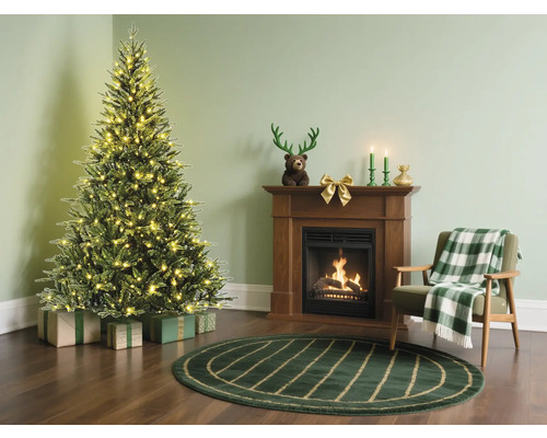 Weihnachtsszene mit geschmücktem Baum, Geschenken, Kamin und Sessel in einem gemütlichen Wohnzimmer.