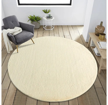Salon avec tapis rond, fauteuil et table d''appoint sur parquet