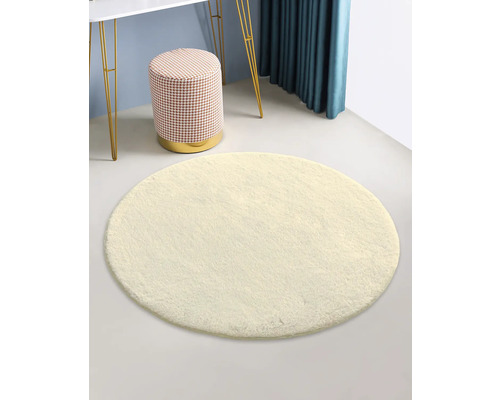 Un tapis rond, un tabouret, une table et un rideau créent une atmosphère d''espace lumineuse et organisée.