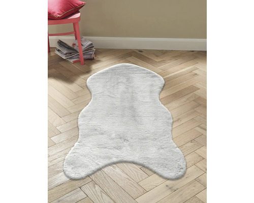 Tapis imitation peau de mouton gris sur plancher en bois