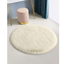 Weisser runder Teppich mit Hocker und Tisch im Hintergrund