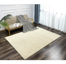 Beiger Teppich in einem hellen Wohnzimmer mit Sofa und Vorhängen