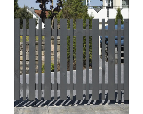 Clôture en bois grise avec des lattes verticales dans le jardin