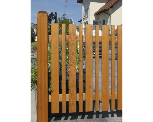 Clôture en bois à l''extérieur avec des lattes verticales de différentes largeurs