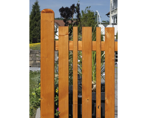 Clôture en bois avec des lattes verticales de différentes largeurs