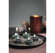 Arrangement décoratif avec des bougies chauffe-plat sur une assiette noire avec des pierres décoratives