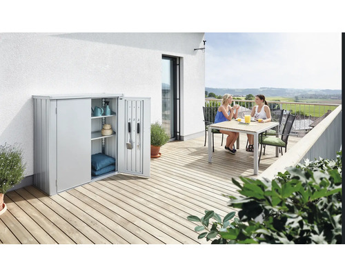 Metall Gartenschrank mit zwei Frauen am Tisch auf einer Terrasse
