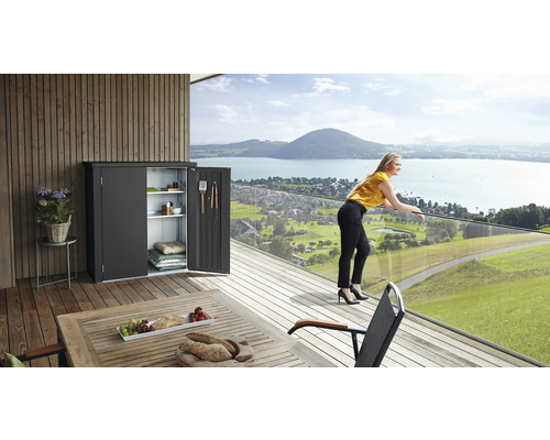 Szene mit einem Geräteschrank mit geöffneten Türen auf einer Terrasse mit Seeblick