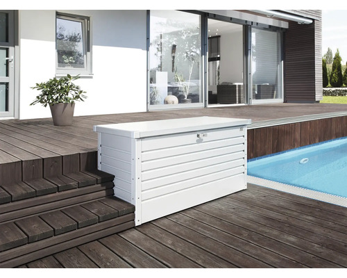 Aufnahme einer weissen Gerätebox aus Metall auf einer Terrasse neben einem Swimmingpool.