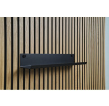 Étagère murale noire sur un mur à panneaux de bois