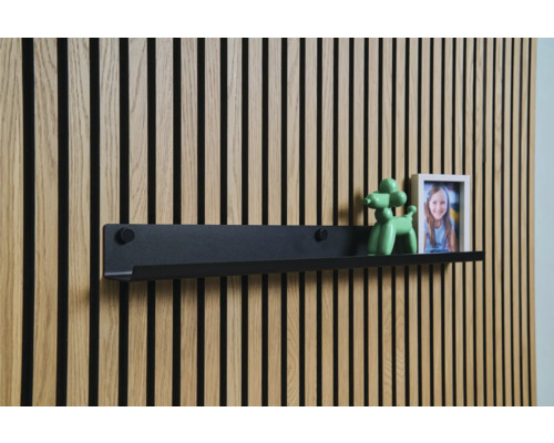 Étagère murale noire devant un lambris en bois avec décoration