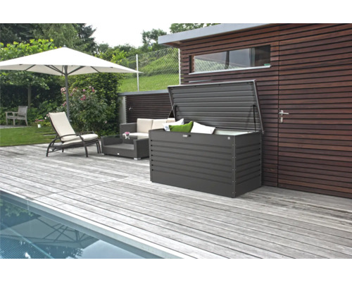 Gartenszene mit Pool, Terrasse, Sonnenschirm, Lounge Möbeln und einer geöffneten Aufbewahrungsbox