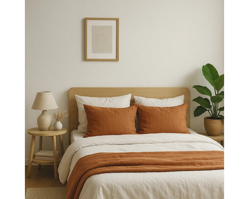 Schlafzimmer mit Bett, Nachttisch und Zimmerpflanze für eine helle und freundliche Atmosphäre.