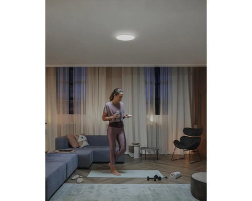 Femme faisant du sport dans un salon avec plafonnier