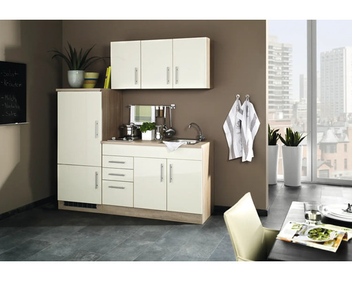 Cuisine compacte avec évier, plaque de cuisson, éléments hauts et réfrigérateur dans un design moderne.