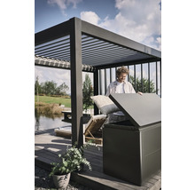 Mann verstaut Kissen in einer Aufbewahrungsbox im Aussenbereich unter einer Pergola.