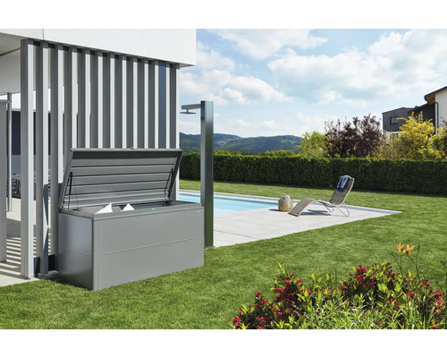 Boîte de rangement biohort LoungeBox 160, 160x70x83,5 cm gris quartz métallique Scène avec un coffre de rangement ouvert dans le jardin près de la piscine