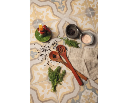 Carreaux décoratifs avec bougeoir, cuillères de cuisine, herbes et épices