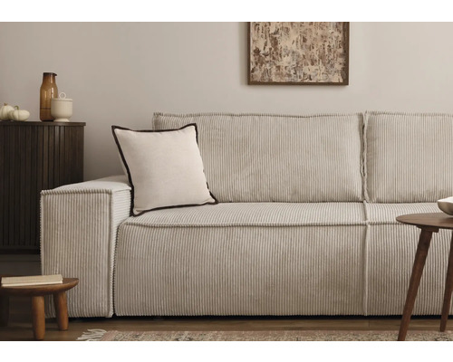 Cordsofa mit Kissen und Beistelltischen in einem Wohnzimmer