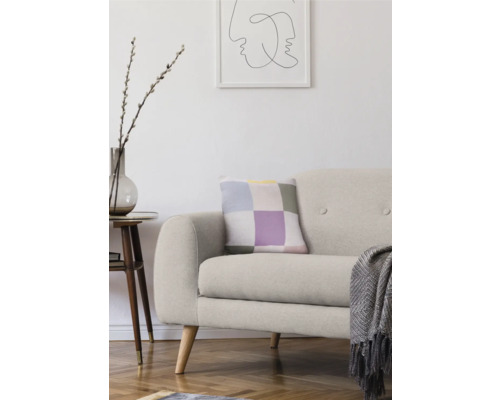 Wohnzimmer mit Sofa, Kissen, Beistelltisch und Dekoration