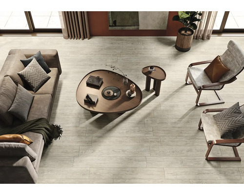 Photo d''intérieur d''un salon avec parquet gris clair, canapé, fauteuil et table basse.