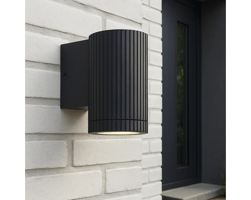 Schwarze Aussenwandleuchte an einer weissen Ziegelwand