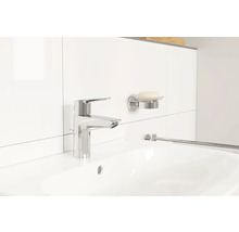 Lavabo avec robinet, porte-savon et porte-serviettes dans une salle de bain lumineuse