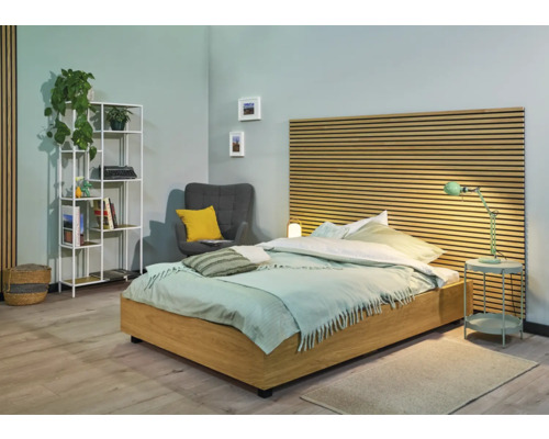 Chambre lumineuse avec lit, table de chevet, étagère et fauteuil