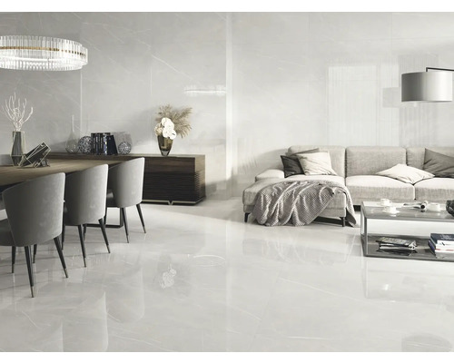 Heller Wohnraum mit Bodenfliesen in Marmoroptik, Esstischgruppe und Wohnzimmerbereich