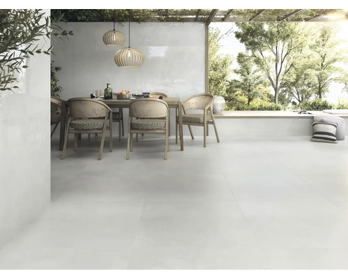 Helle Terrasse mit Esstisch, Stühlen und passenden Bodenfliesen für den Aussenbereich.