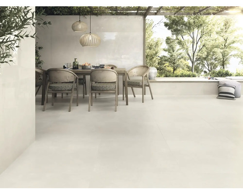 Aménagement lumineux de terrasse avec sol carrelé, table à manger et vue sur le jardin